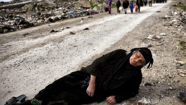 An Iraqi woman lies on the ground as civilians flee Mosul while Iraqi forces advance inside the city during fighting against the so-called Islamic State group’s fighters on March 8, 2017.ARIS MESSINIS/AFP/Getty Images